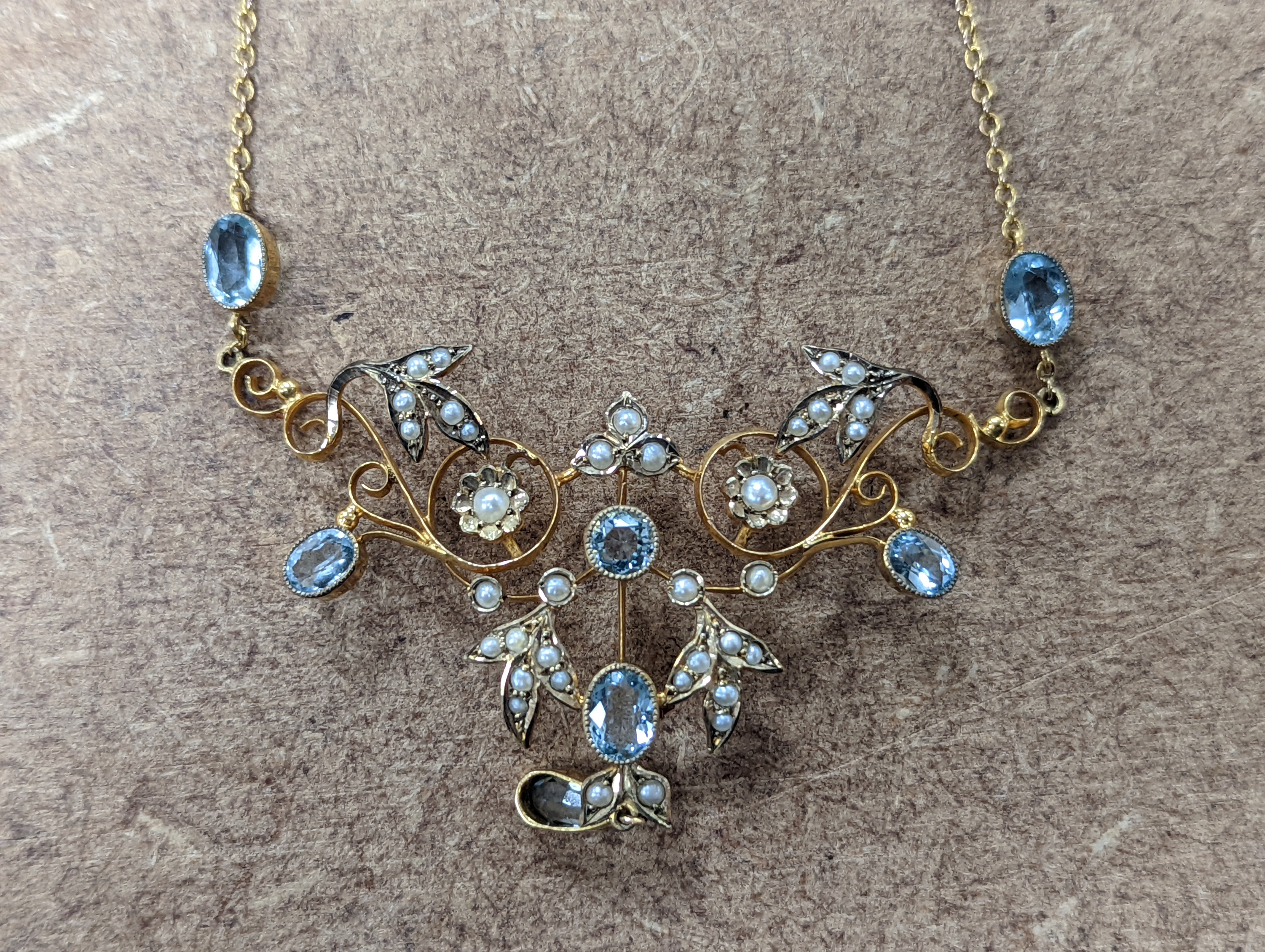 An Edwardian 9ct, aquamarine and seed pearl set drop pendant necklace, 40cm, gross weight 7.2 grams.